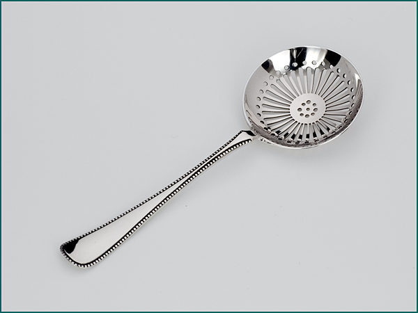 Zilveren natfruit/strooilepel met parelrand uit 1922-0