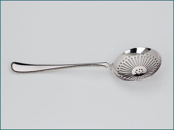 Zilveren natfruit/strooilepel met parelrand uit 1922-6984